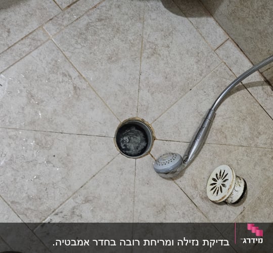 פתח ניקוז פתוח עם מכסה מוסר ומקלחת יד